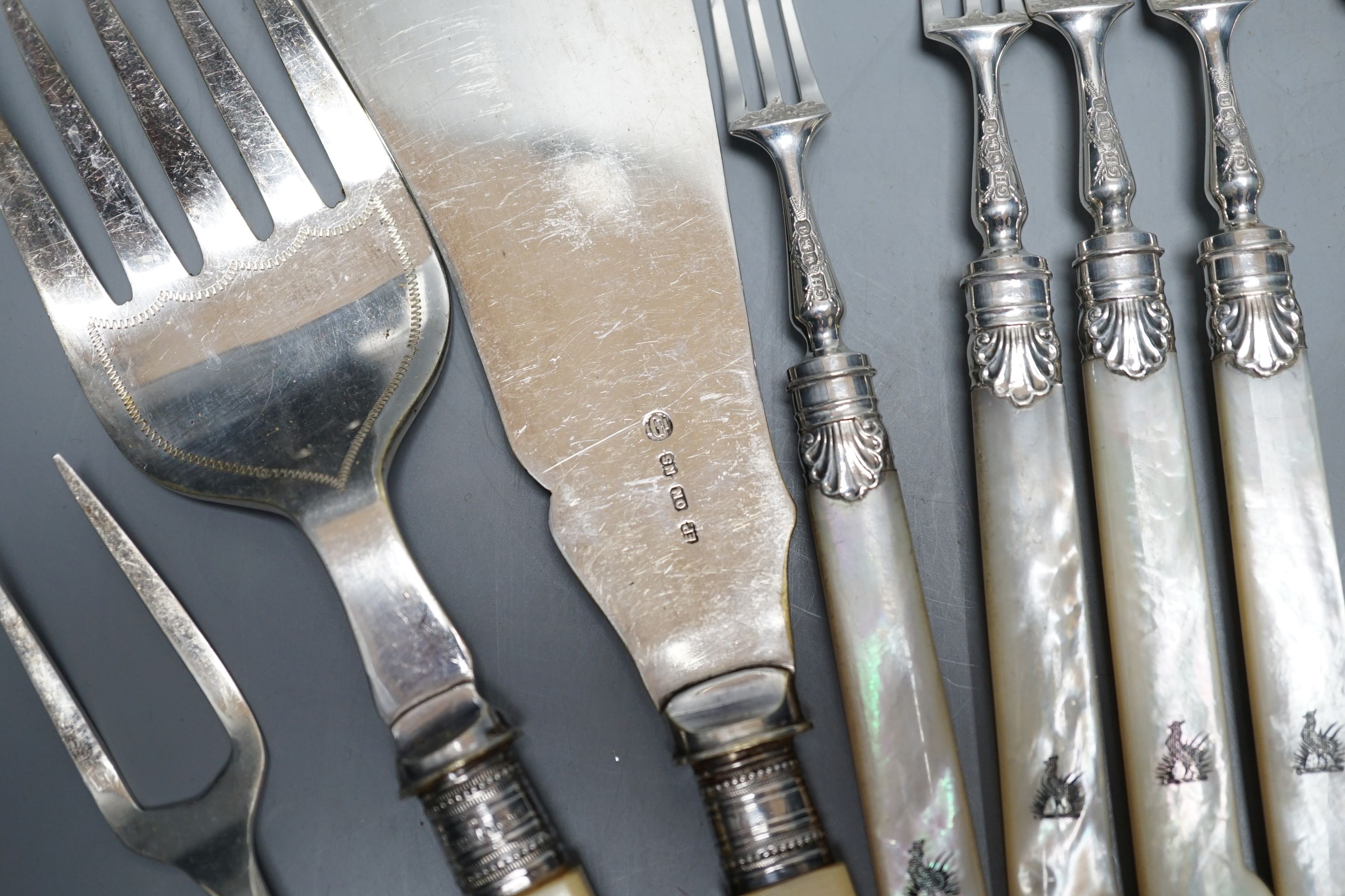 Six pairs of George V mother of pearl handled silver dessert eaters, George Howson, Sheffield, 1921, a pair of silver sugar tongs and assorted plated flatware.